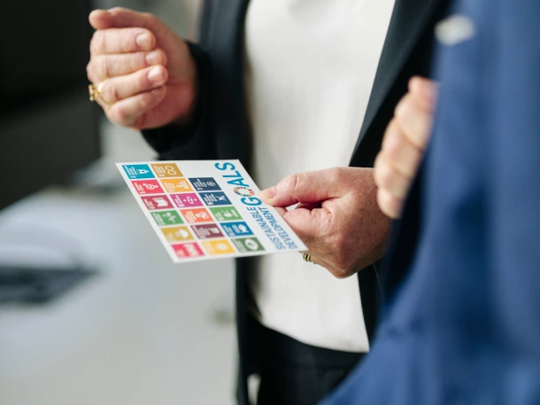 Ein Mensch hält eine Abbildung der 14 Sustainability Goals in der Hand